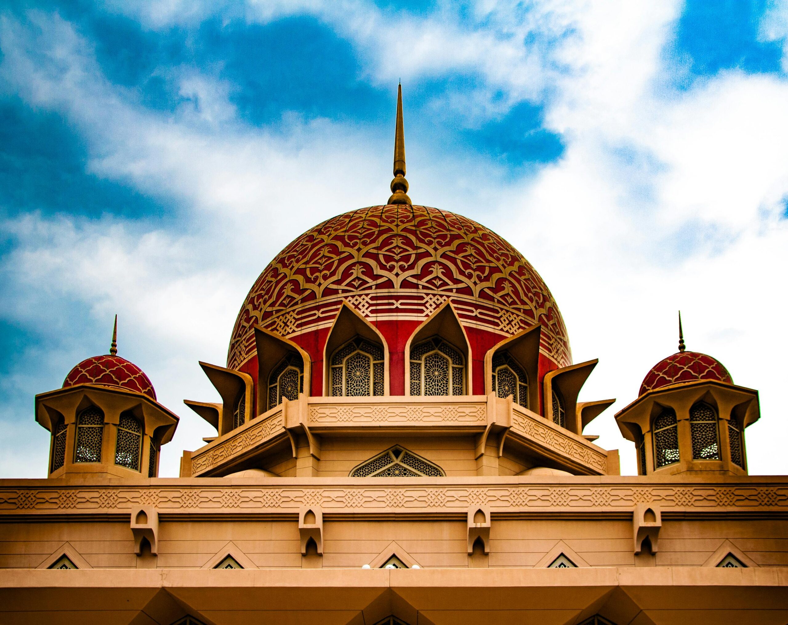 Stunning view of Putra Mosque's domes against a bright sky, showcasing Islamic architecture.